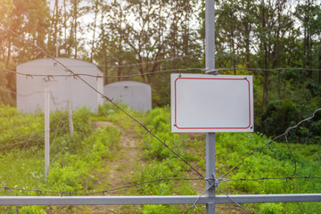 Forbidden area fenced with a barbed wire fence. Gate with padlock closed to the key. Border of States