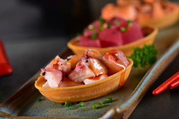 Chopped raw salmon, tuna and octopus canapes
