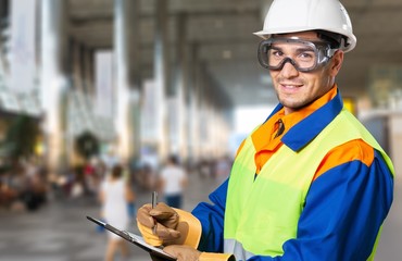 Portrait of handsome builder in helmet writing