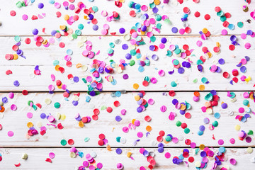 Party background. Party colorful confetti on white wooden background. Top view. Copyspace