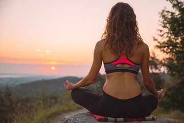 Fototapeta na wymiar woman do yoga exercises at top of the hill on sunrise