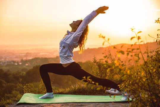 woman making exercise on the hill on sunrise
