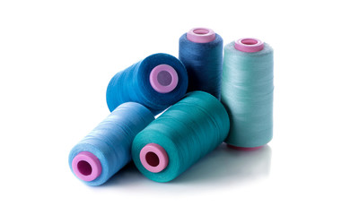 A bobbin with threads in blue tones on a white isolated background. accessories for sewing