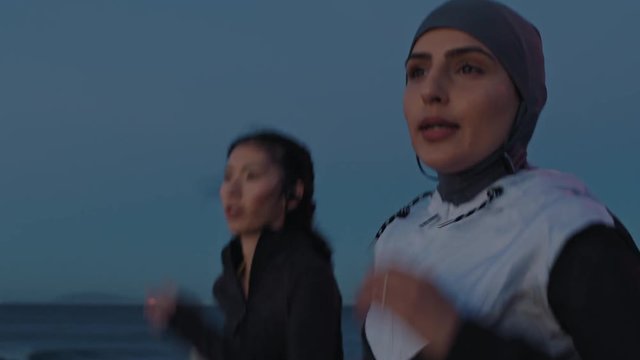 diverse young women athletes running training competitive cardio workout athletic female overtaking jogging on calm evening seaside