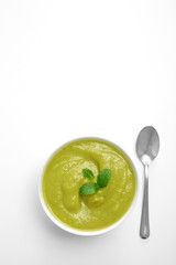 Vegetable broccoli or spinach potage soup in a white bowl viewed from above isolated on a white background. Top view. Copy space