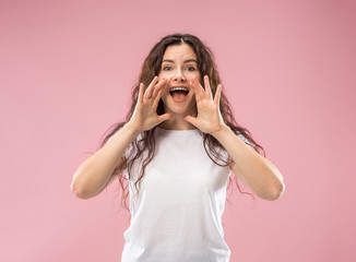 Do not miss. Young casual woman shouting. Shout. Crying emotional woman screaming on studio background. Female half-length portrait. Human emotions, facial expression concept. Trendy colors