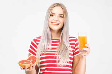 Portrait of a beautiful woman holding orange grapefruit juice glass. Smiling girl isolated portrait over white. Casual clothes.