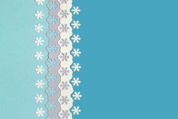 Colorful festive background with cut out snowflakes