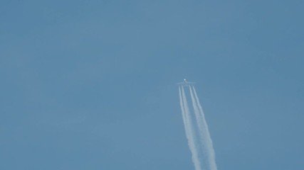 Airplane in flight, making a white stripe in the blue sky, called a contrail, condense trail or vapour trail