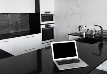Fototapeta na wymiar Smart Display Concept. Mock up laptop on the table in modern kitchen room.