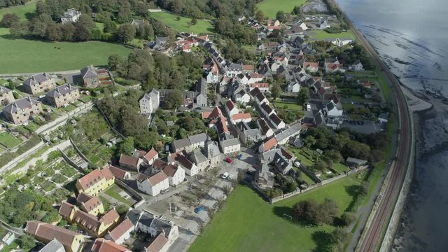 Aerial footage of the historical village of Culross on the North shore of the River Forth. White-harled houses, red-tiled roofs and cobbled streets. A location for the hit television series Outlander.