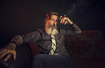 Porträt eines attraktiven, bärtigen, modernen Geschäftsmannes, vor einem dunklen Hintergrund