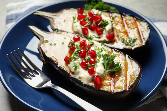 Plate with tasty fried eggplants on gray table