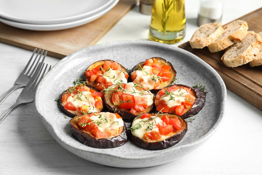 Baked eggplant with tomatoes, cheese and thyme on table