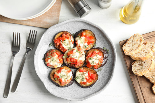 Flat lay composition with baked eggplant, tomatoes and cheese on table