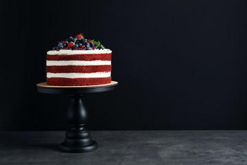 Stand with delicious homemade red velvet cake and space for text on black background - obrazy, fototapety, plakaty