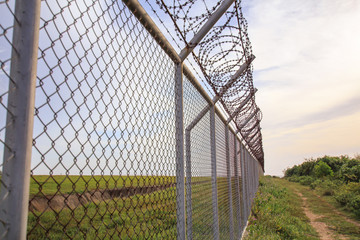 Chain link fence with grass field Phuket International Airport