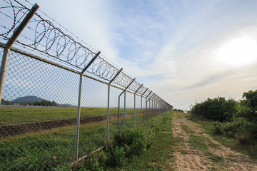 Chain link fence with grass field Phuket International Airport