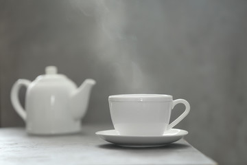 Obraz na płótnie Canvas Cup of tea and saucer on table against gray background