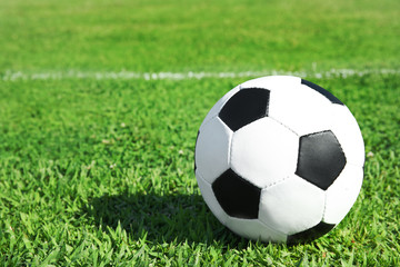 Fototapeta na wymiar Soccer ball on fresh green football field grass. Space for text