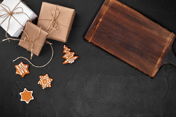Christmas composition. Xmas cookies, gifts, festive decoration on black background. Flat lay, top view, with copy space.