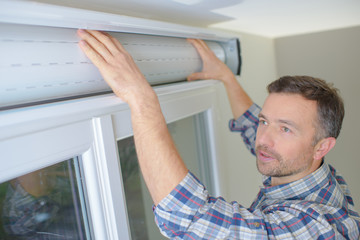 man installing cassette roller blinds on windows