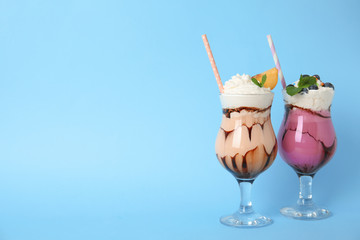Glasses of tasty milk shakes and space for text on color background