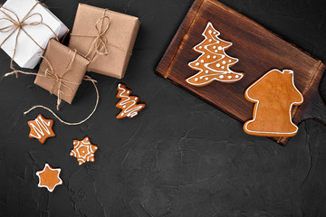 Christmas composition. Xmas cookies, gifts, festive decoration on black background. Flat lay, top view, with copy space.