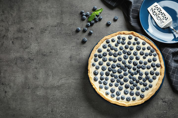 Flat lay composition with tasty blueberry cake and space for text on gray table