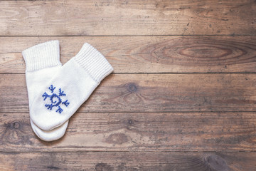 knitted mittens on the wooden floor. Winter concept