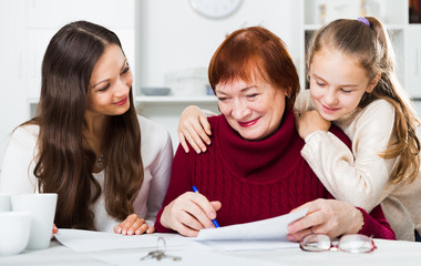 Smiling senior woman with family writing papers