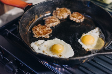 Sausage and eggs being cooked in cast iron skillet on a gas stove. Stove from RV. Full time RV lifestyle