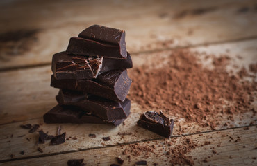 Close-up of stacked dark chocolate on wooden background 