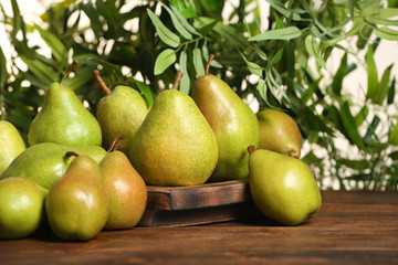Fresh ripe pears on wooden table against blurred background