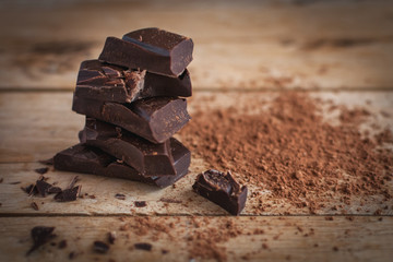 Close-up of stacked dark chocolate on wooden background 