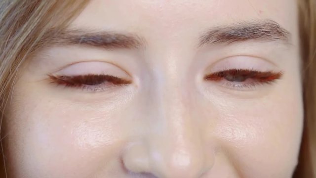 well-groomed woman after procedure of lash extensions is demonstrating her green eyes