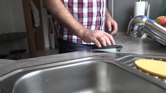 The man is sharpening a kitchen knife