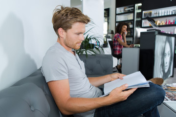 guy reading journal at hairdressers