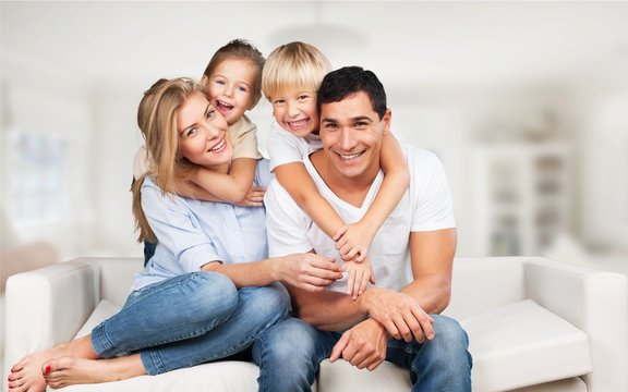 Beautiful smiling family sitting at sofa at