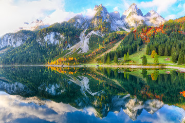 autumn scenery with Dachstein mountain summit reflecting in crystal clear Gosausee mountain lake