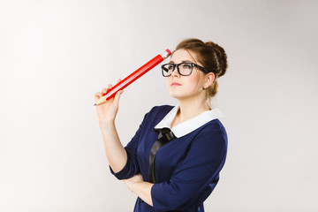 Woman holding big oversized pencil thinking about something
