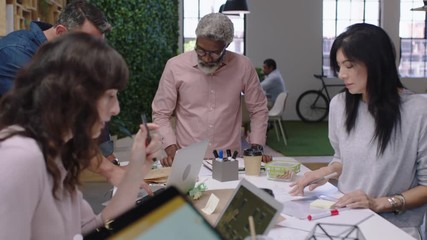 business people meeting software developer team design mobile phone application multi ethnic group brainstorming sharing creative ideas for communication app using tablet in boardroom close up