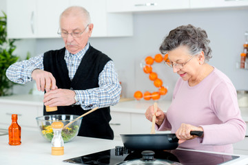 senior couple cooking and having fun in the kitchen