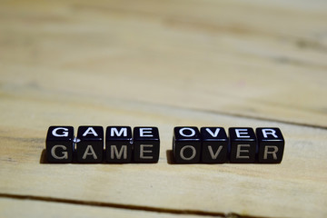 Game over message written on wooden blocks. education and motivation concepts. Cross processed image on Wooden Background