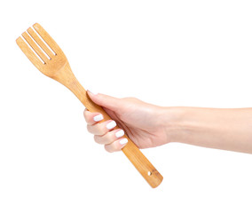 Wooden kitchen fork in a hand on a white background isolation