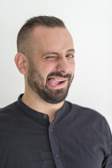 Fototapeta premium młody biznesmen z tatuażem, czarną koszulką, brodą i czarnymi włosami na białym tle