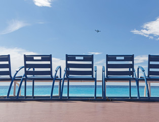 row of blue chairs at beach in Nice, France
