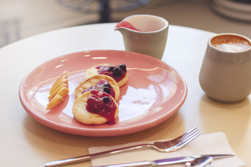 Breakfast in the cafe cheesecakes with fruit and coffee