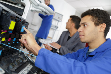 apprentice is learning to fix a printer