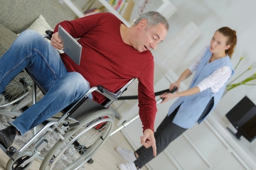 Obraz premium man wheelchair giving orders to carer